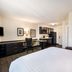 Sonesta Simply Suites Pittsburgh Airport room with bed, work desk, kitchenette and seating area