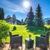 Das Bergmayr - Chiemgauer Alpenhotel in Inzell: patio seating with mountain lawn and sunlit trees