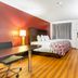 Red Roof Inn Phoenix-Midtown guest room with king bed, desk, chair, dresser and wall-mounted TV