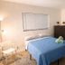 La Mare Fort Lauderdale Airport bedroom with queen bed, blue bedspread, windows and dresser in Fort Lauderdale