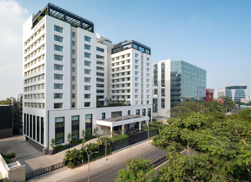 Pullman Chennai Anna Salai towers above Anna Salai with a modern white facade and street view in Chennai.