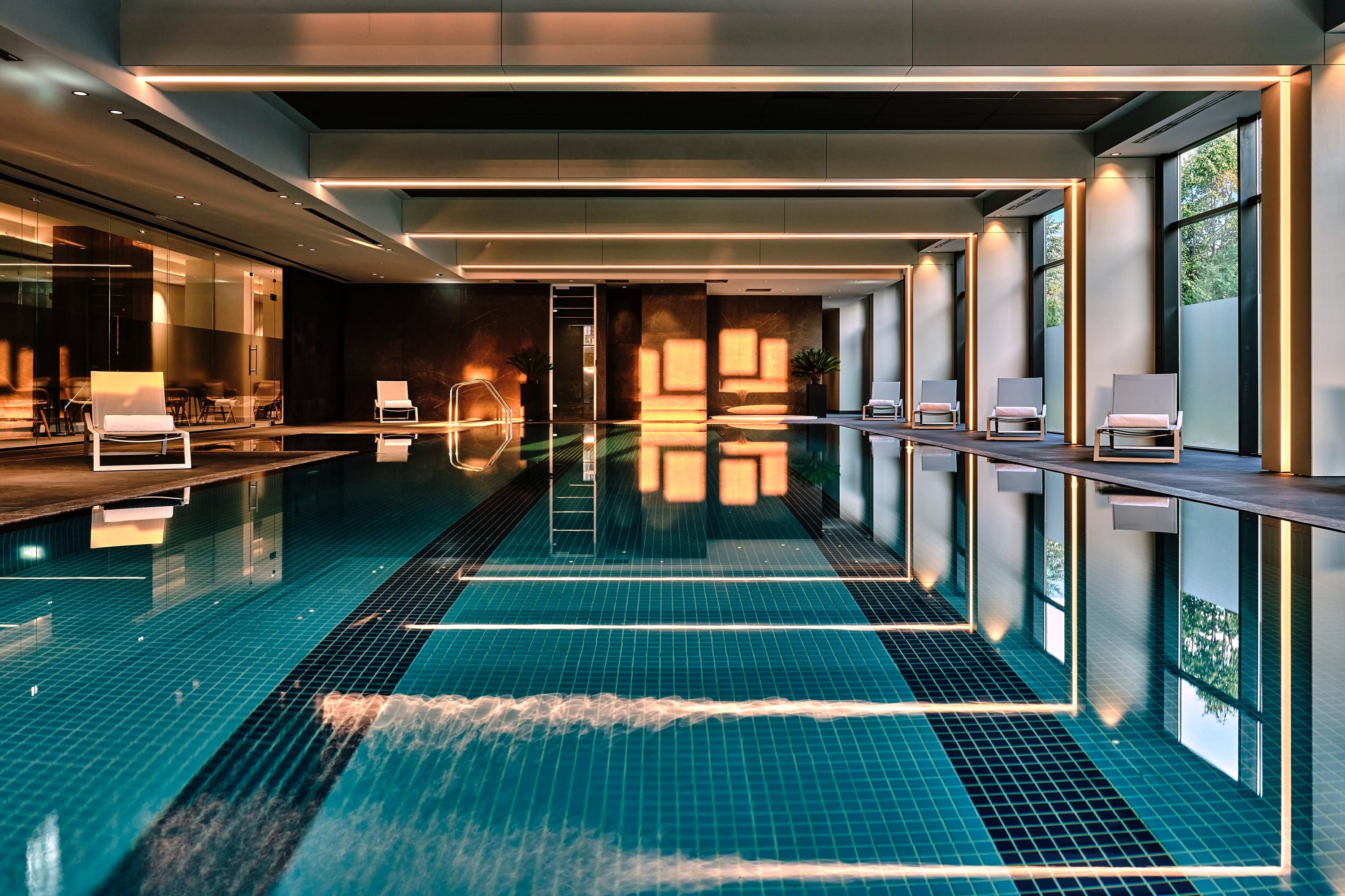 Crowne Plaza Sofia by IHG indoor pool with floor-to-ceiling windows and modern lounge seating
