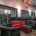 Poshpacker Chengdu Flipflop Hostel lounge with red and black leather seating and pool table in Chengdu