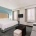 Homewood Suites by Hilton Bonita Springs Naples North guest room with king bed, sofa, TV and window seating