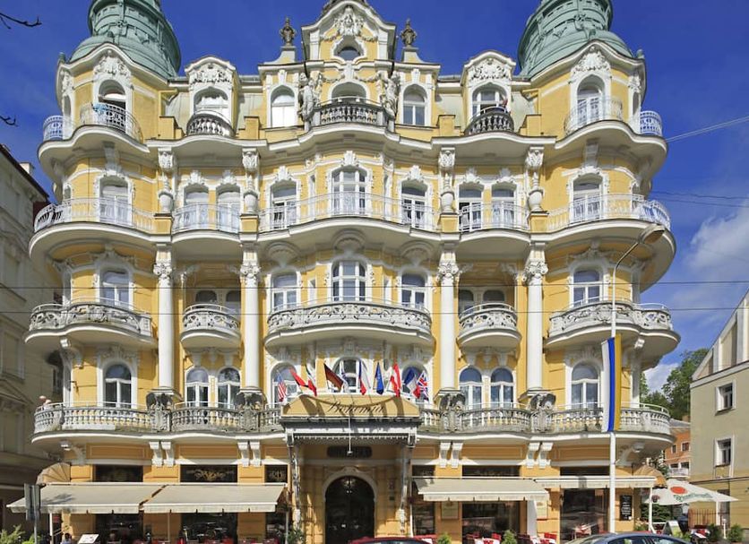Orea Spa Hotel Bohemia in Mariánské Lázně, ornate yellow historic hotel facade with balconies and flags