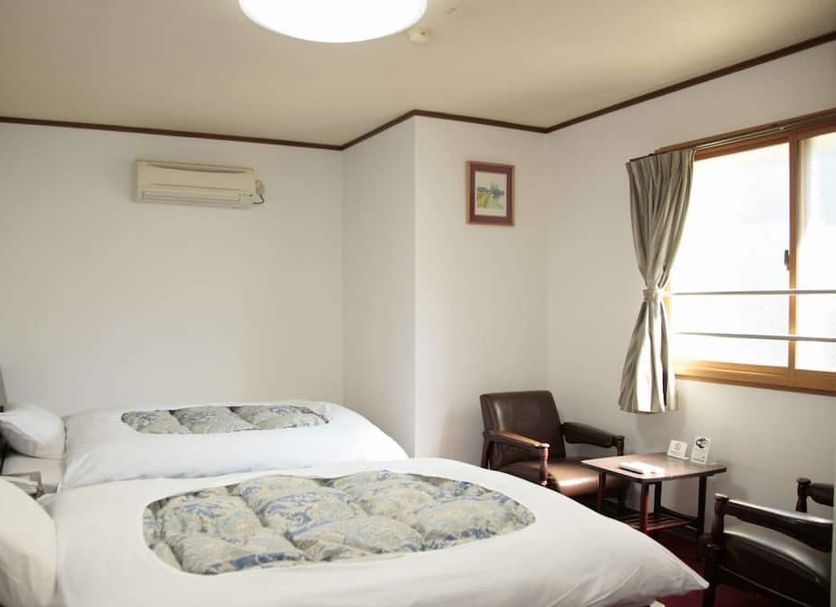 Business Kaneko Hotel in Sasebo guest room with twin beds, window, and seating area