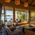 Victoria Falls River Lodge lounge with river views, open doors, and wood deck seating in Victoria Falls