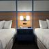 AmericInn by Wyndham Galesburg guest room with two beds and a bedside lamp