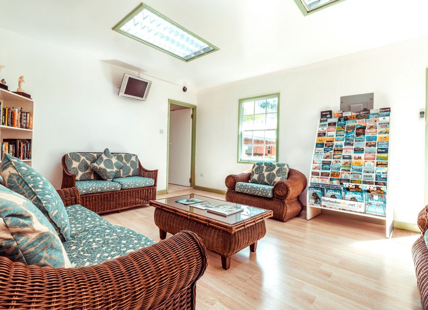 Worthing Court Apartment Hotel in Bridgetown lounge with wicker sofas, coffee table, skylight and postcard rack