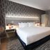 Radisson Plaza Hotel at Kalamazoo Center, MI room with king bed, patterned wall, floor lamp and rug