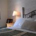 Glenan Lodge Self Catering in Inverness bedroom with wrought-iron headboard, bedside lamp and window