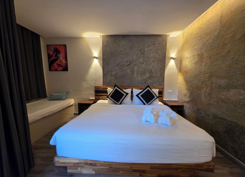 TT Naiyang Beach Phuket room in Sakhu with a double bed, twin bedside lamps, and curtained window seat