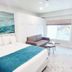 Bridgewalk, a Landmark Resort in Bradenton Beach room with bed, sofa, ocean-themed art and balcony view