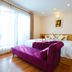 Royal Hotel Hanoi room with purple sofa, king bed and bright window curtains
