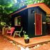 Up The Creek Backpacker's Lodge in Roberts Creek: rustic cabin with wooden deck and chairs in forest setting