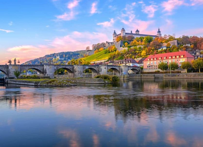 Gasthaus & Hotel Drei Lilien in Werbach with river, stone bridge, and hillside castle view