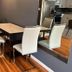 Nwk 457 Room 111-A in Newark dining table with four white chairs beside a wall mirror