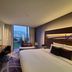 Novotel Ambassador Suwon room with large window, city view and bed