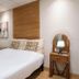 The Goose House Ubon in Ubon Ratchathani bedroom with bed, wood headboard, and bedside lamp