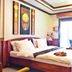 Blue Diamond Resort Ko Tao guest room with king bed, balcony door, TV, and wall art