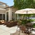 Hilton Garden Inn Roseville patio with outdoor seating, umbrellas and glass doors