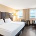 NH Danube City Vienna guest room with twin beds, desk, and city view