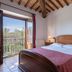 Le Rocche di Valiano, Vagliagli: bedroom with wood-beamed ceiling and balcony overlooking countryside