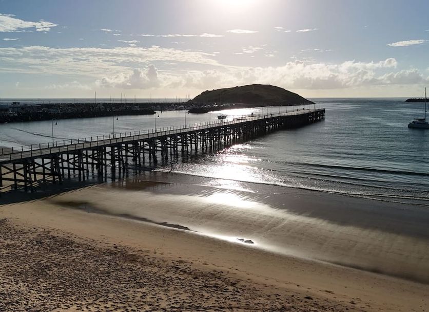 Matador Motor Inn in Coffs Harbour with pier over calm beach and sunlit ocean view