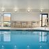 Hampton Inn Battle Creek indoor pool with lounge chairs and windows