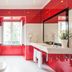 Vila Nova Guesthouse bathroom in Lisbon with red tile walls, walk-in shower, and white sink vanity