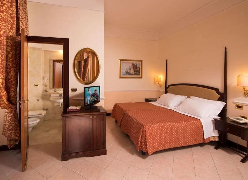 Hotel Nizza, Rome guest room with double bed, bedside lamps, and bathroom doorway