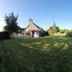 Le Clos Loret in Saint-Germain-du-Corbéis with a large grassy garden beside a small house and open sky