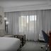 Courtyard by Marriott Greensboro Airport guest room with sofa, desk, and window with sheer curtains
