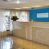 Avalon Inn Sandusky lobby with front desk, blue accent wall, and tiled floor