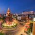 The Heritage Sathorn Suite Hotel in Bangkok with city traffic circle and illuminated temple pagoda at dusk