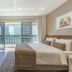 Fusion Hplus Express + room in Brasilia with king bed, desk and balcony view of city buildings