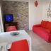 Apartments Antonio in Cavtat with red sofa, dining table and TV in a bright apartment living area.