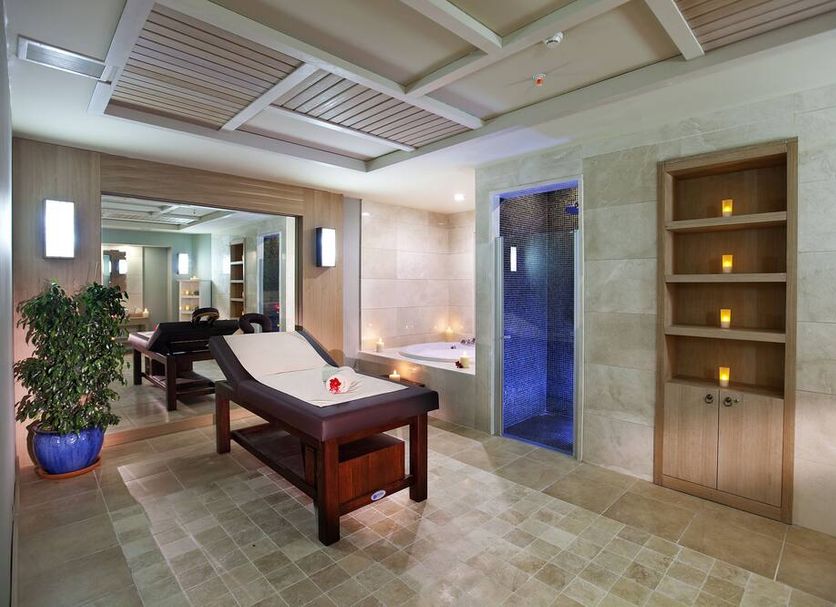 Quadas hotel in İçmeler spa treatment room with massage table, blue-lit shower and candle shelf