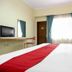 RedDoorz @ Seturan Raya 2 in Depok room with bed, desk, chair, TV, and window with curtains