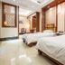 Changle Inn in Yangzhou twin room with two beds, wood paneling, and ornate wall accents