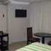 Hotel Graham Villahermosa room with desk, wall-mounted TV, round table, and curtained window