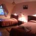 Hotel Savoy in La Paz guest room with two twin beds, bedside lamps, and a window with curtains
