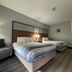 AmericInn by Wyndham Galesburg guest room with two beds, sofa and bedside lamps