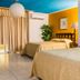 Gran Hotel Paris in La Ceiba guest room with two beds, tiled floor, blue ceiling and beige curtains