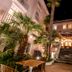 La Palmeraie in La Baule-Escoublac at night, with palm trees framing a lit entrance and stone steps.