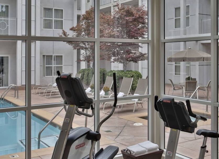 Corporate Inn Sunnyvale fitness room with pool view through large windows in Sunnyvale