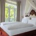 Hotel Weisses Haus in Bad Kissingen bedroom with carved canopy bed, balcony doors and floral decor