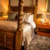 The Peel Aldergate, Tamworth: four-poster bed in a warmly lit hotel room with bedside lamps