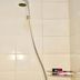 Infinite Residence Bandung shower with green showerhead and wall-mounted caddy in a tiled bathroom