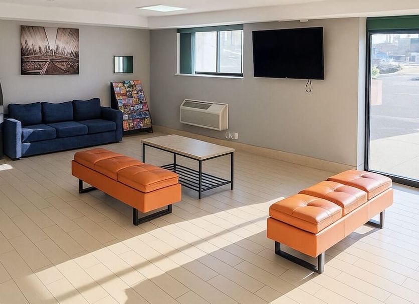 Floral Park Motor Lodge lounge in Queens with sofa seating, TV, and bright windows